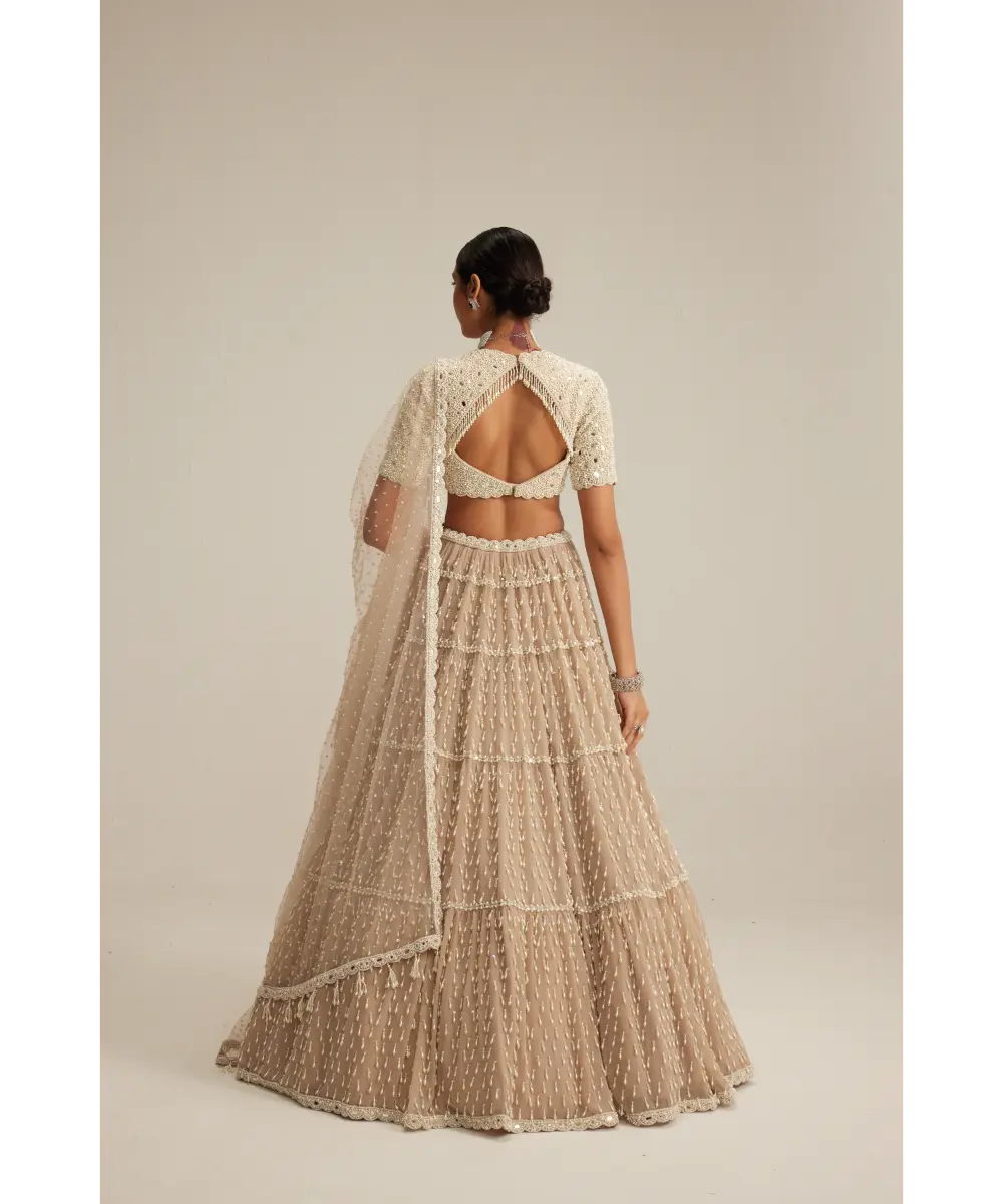 VVANI VATS- Light Beige Pearl Drop Multi Tier Lehenga With High Neck Blouse Set.